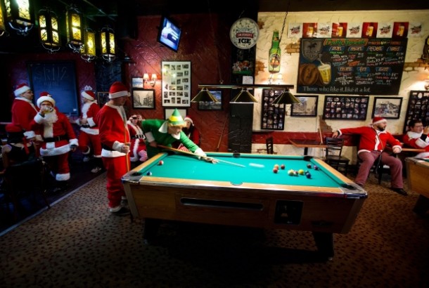 Santa playing pool with elf